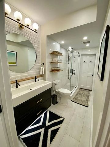 a bathroom with a double vanity sink toilet and mirror
