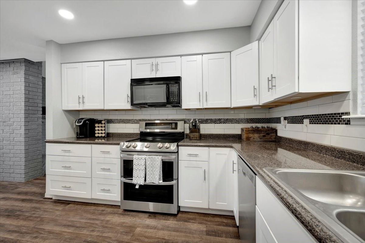 2610 Loganberry Circle Seabrook, TX 77586 - Photo 16 of 35 a kitchen with stainless steel appliances granite countertop a sink a stove and a microwave