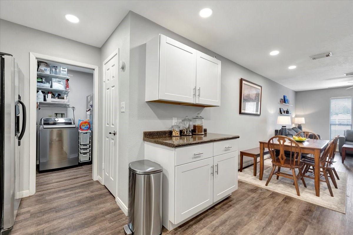 2610 Loganberry Circle Seabrook, TX 77586 - Photo 17 of 35 a kitchen with stainless steel appliances granite countertop a stove top oven a refrigerator a dining table and chairs with wooden floor