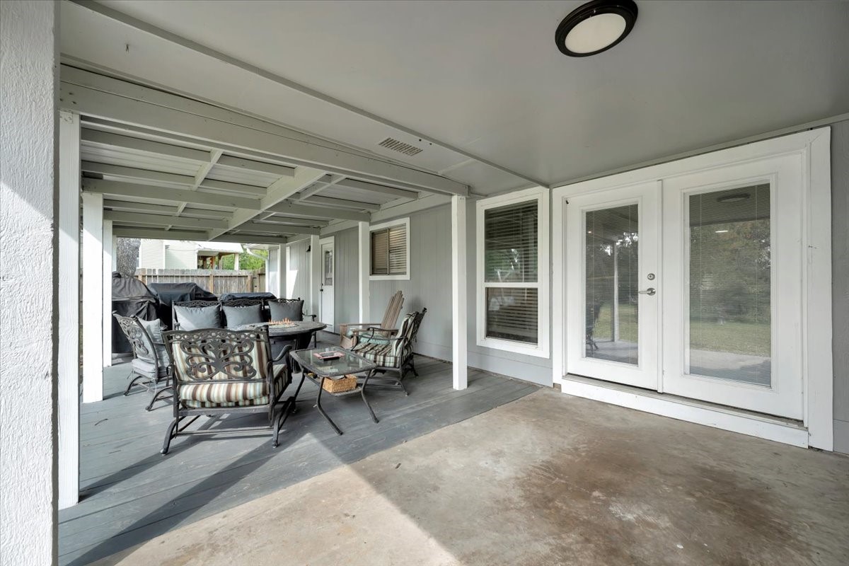 2610 Loganberry Circle Seabrook, TX 77586 - Photo 32 of 35 a view of a patio with table and chairs and floor to ceiling window