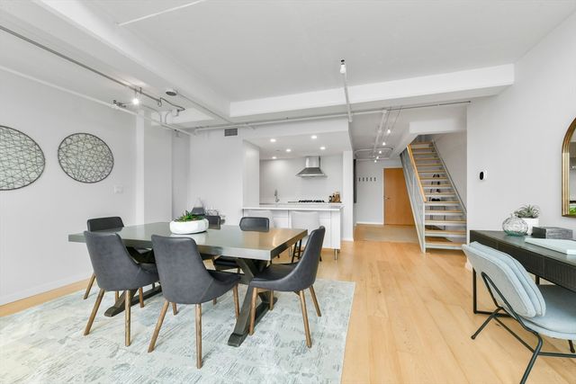 a view of a dining room and livingroom with furniture wooden floor and a clock
