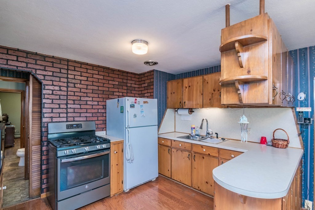 401 Stapleton Road Springfield, MA 01109 - Photo 10 of 35 a kitchen with a refrigerator a stove and wooden cabinets