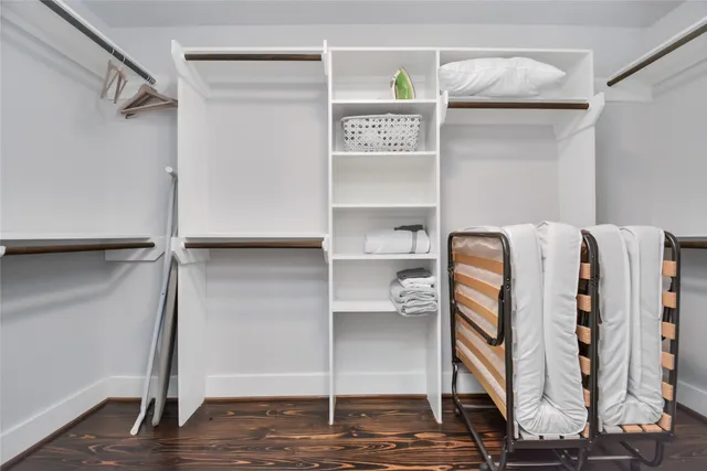 a view of walk in closet with clothes and shoes