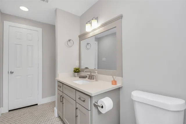a bathroom with a sink vanity mirror and toilet
