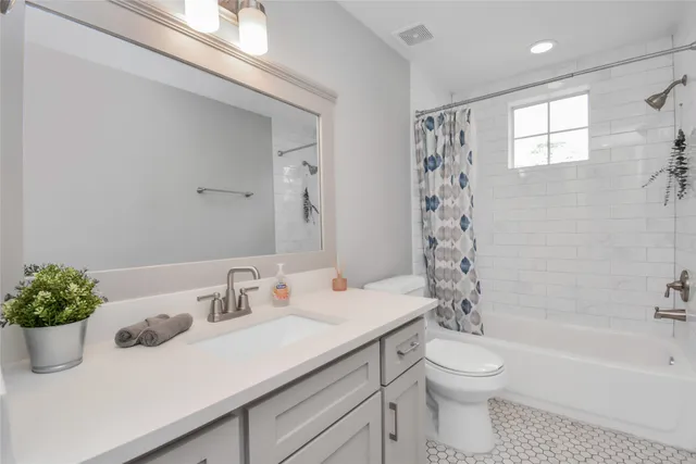 a bathroom with a sink a toilet a tub and shower