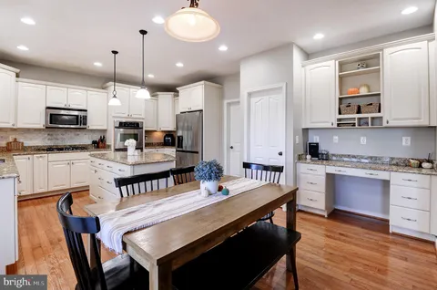 a kitchen with kitchen island granite countertop a sink a counter space appliances and cabinets