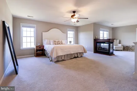 a spacious bedroom with a bed and a chandelier