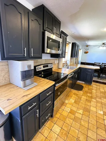 a large kitchen with stainless steel appliances granite countertop a refrigerator and a stove