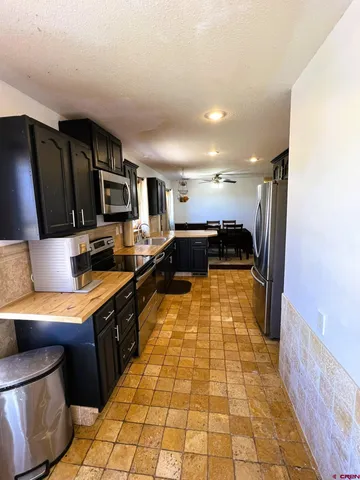 a kitchen with stainless steel appliances granite countertop a refrigerator and a stove top oven