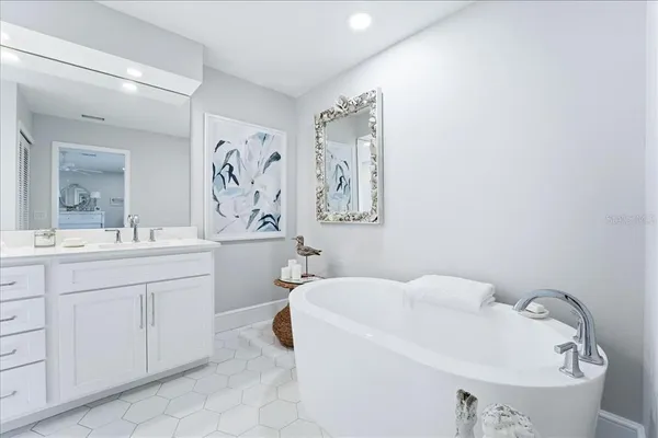 a bathroom with a double vanity sink mirror and bathtub
