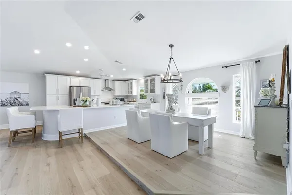 a kitchen with stainless steel appliances granite countertop a sink dishwasher a refrigerator and microwave with wooden floor