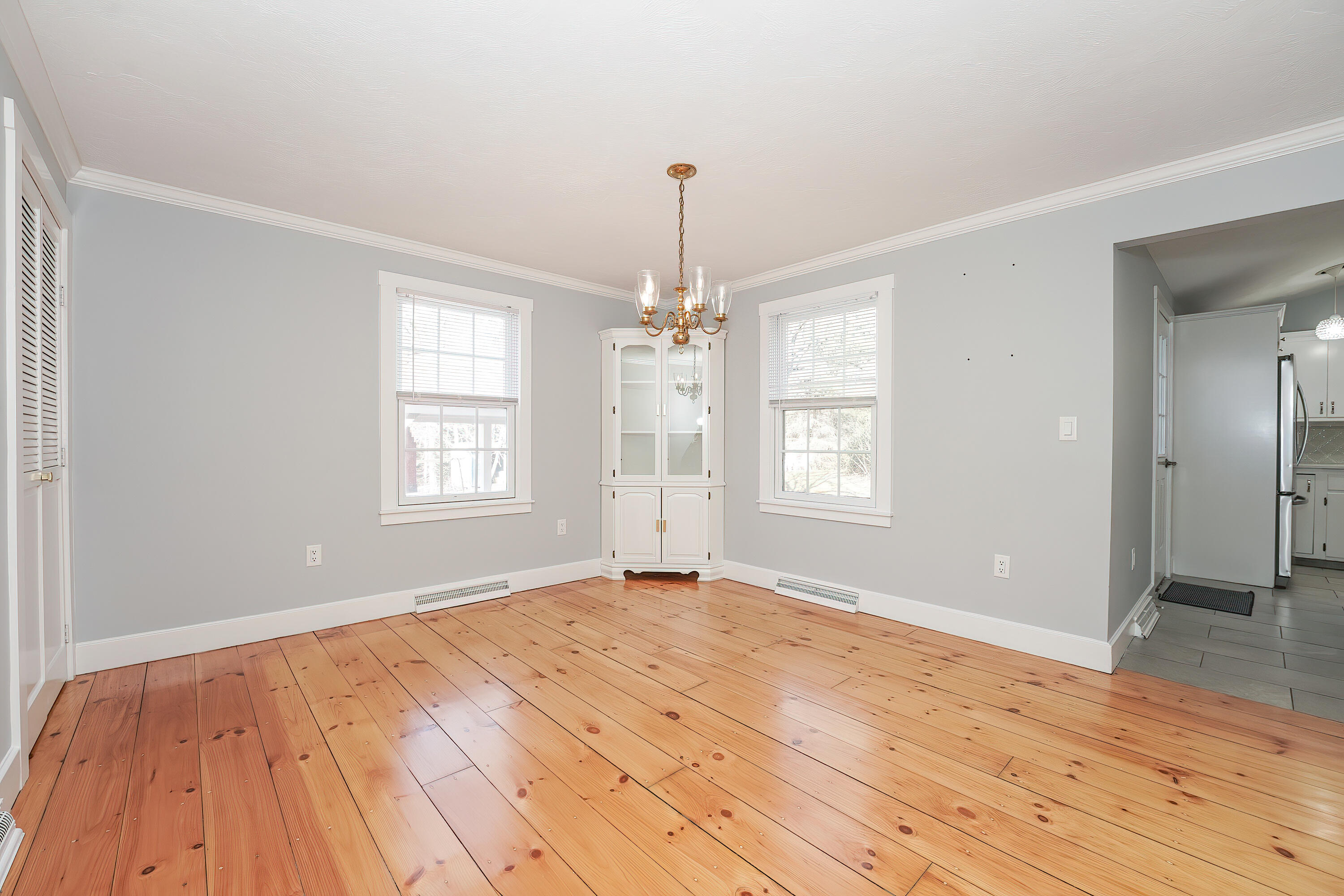 240 Oak Street West Barnstable, MA 02668 - Photo 9 of 89 an empty room with wooden floor chandelier and windows