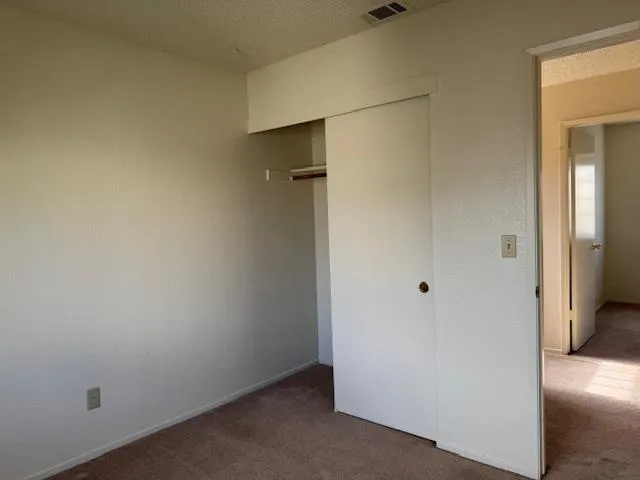 an empty room with closet and a bathroom