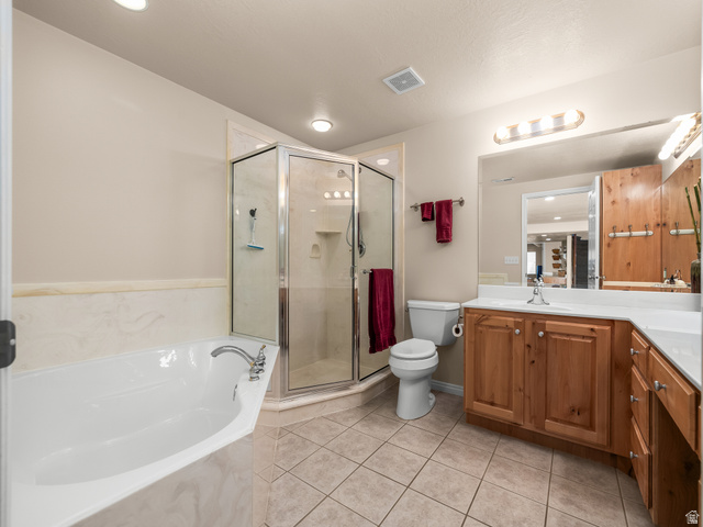 1602 Renaissance Way Springville, UT 84663 - Photo 27 of 42 Bathroom featuring a corner soaking tub, glass-enclosed shower, wood-finish vanity with a white countertop, and tiled flooring