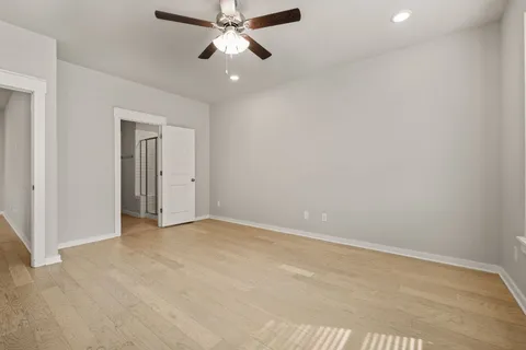 an empty room with chandelier fan