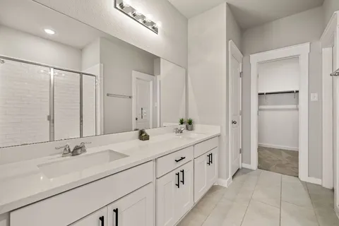 a bathroom with double sink and a mirror