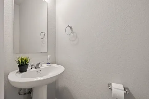 a white sink sitting under a bathroom mirror