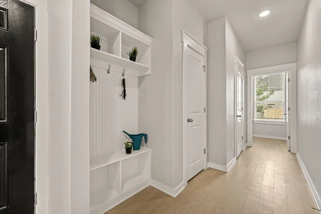 a view of a hallway with closet and wooden floor