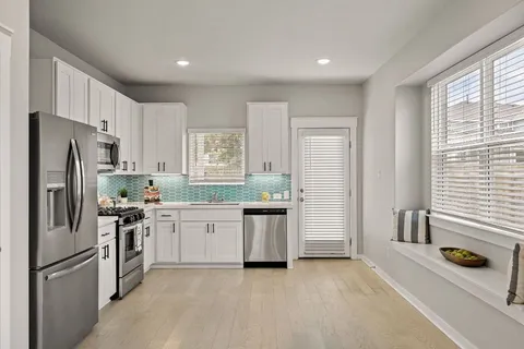a kitchen with a refrigerator and a stove top oven