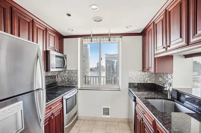 a kitchen with stainless steel appliances granite countertop a refrigerator and a stove