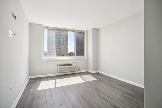 a view of a room with wooden floor and window