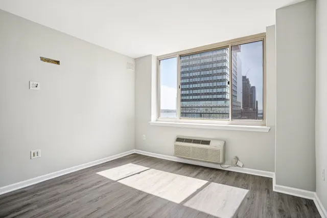 a view of an empty room with wooden floor