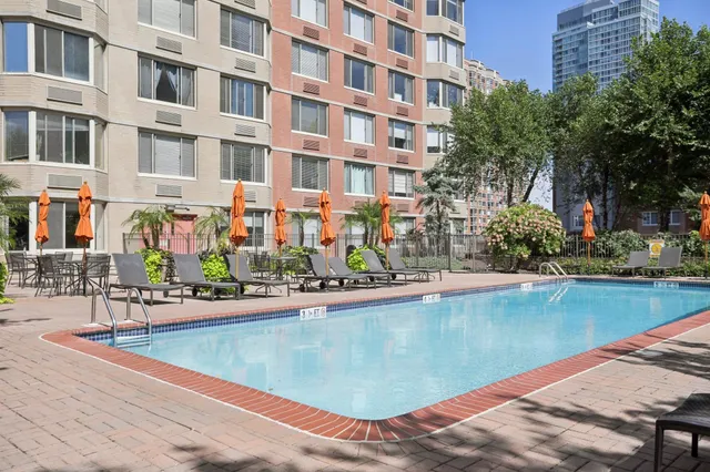 a front view of brick building with yard and seating space