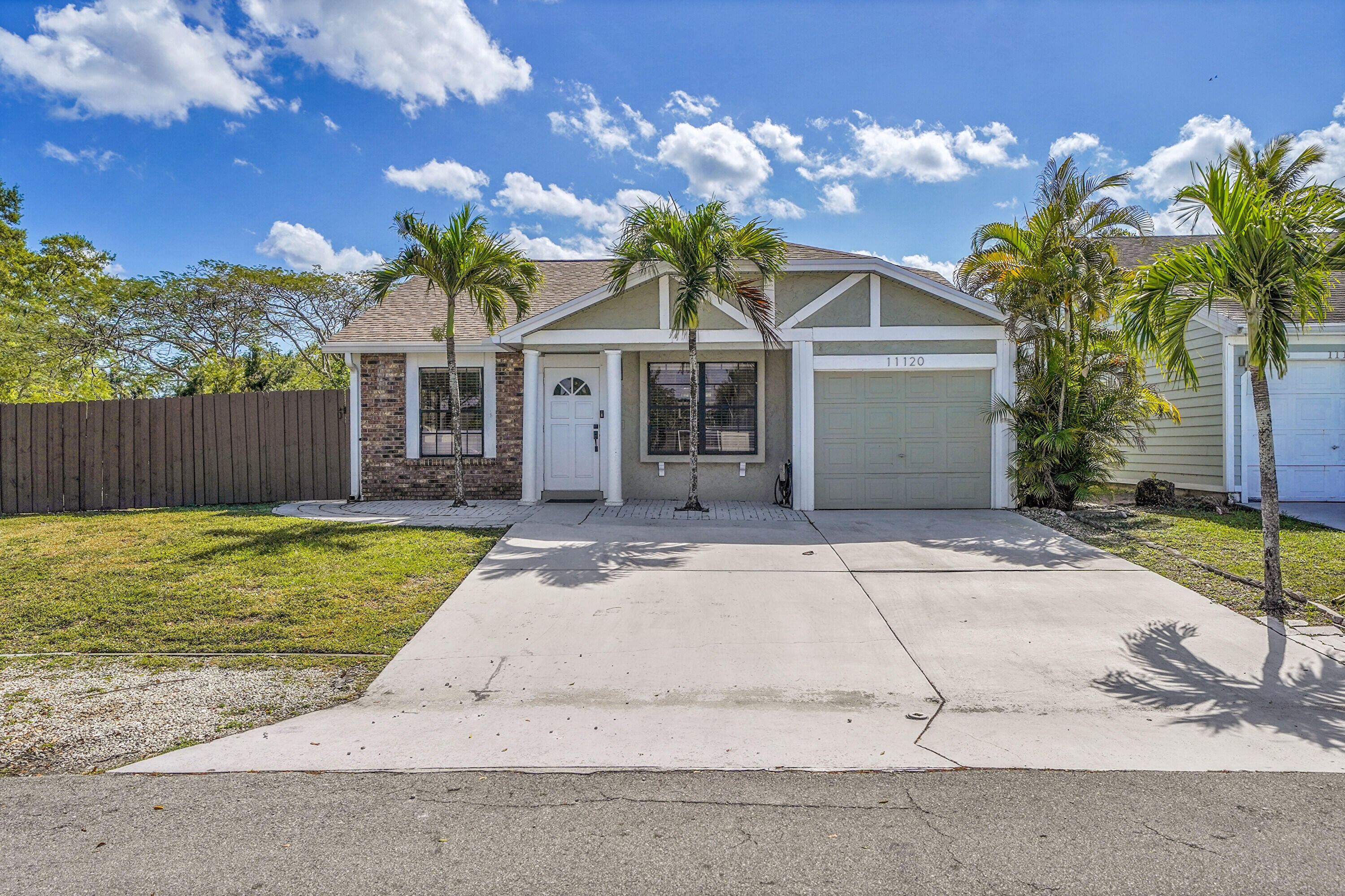 11120 North Terradas Lane Boca Raton, FL 33428 - Photo 3 of 57 a front view of a house with a garden and trees