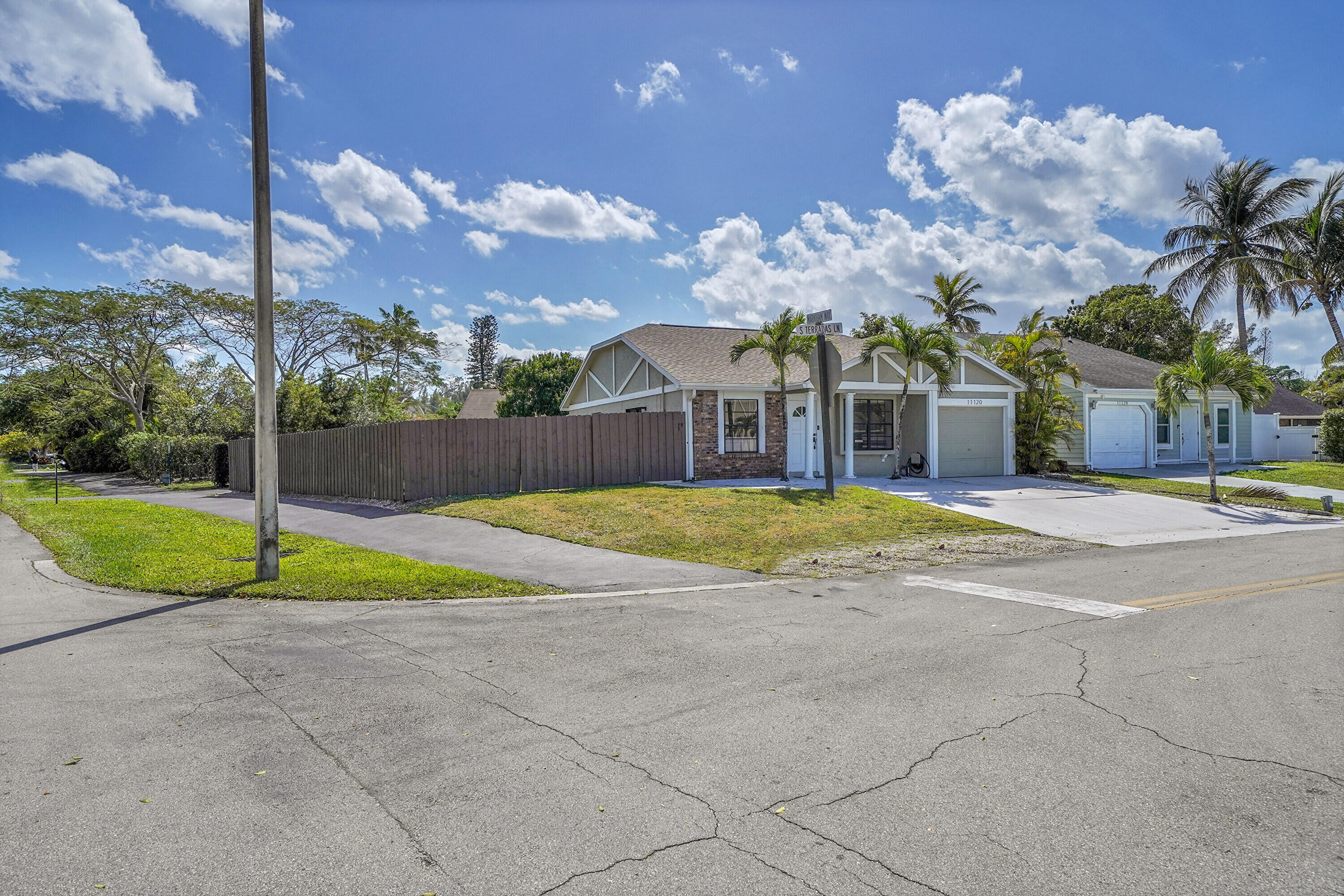 11120 North Terradas Lane Boca Raton, FL 33428 - Photo 4 of 57 a view of yellow house with swimming pool and tall trees