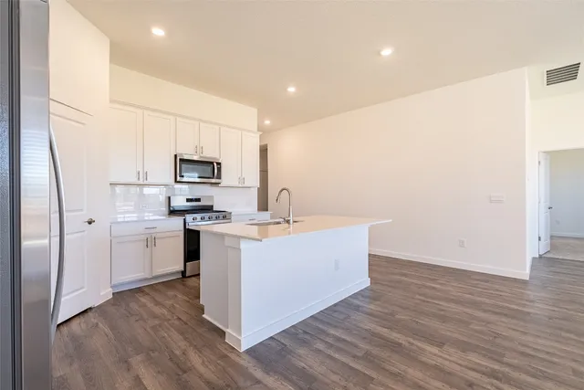 a kitchen with white cabinets and stainless steel appliances