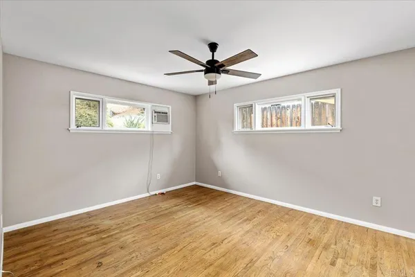 a view of a big room with wooden floor and a ceiling fan