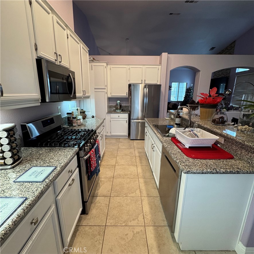 44528 Camolin Lane Lancaster, CA 93534 - Photo 69 of 75 a kitchen with stainless steel appliances granite countertop a sink stove and cabinets