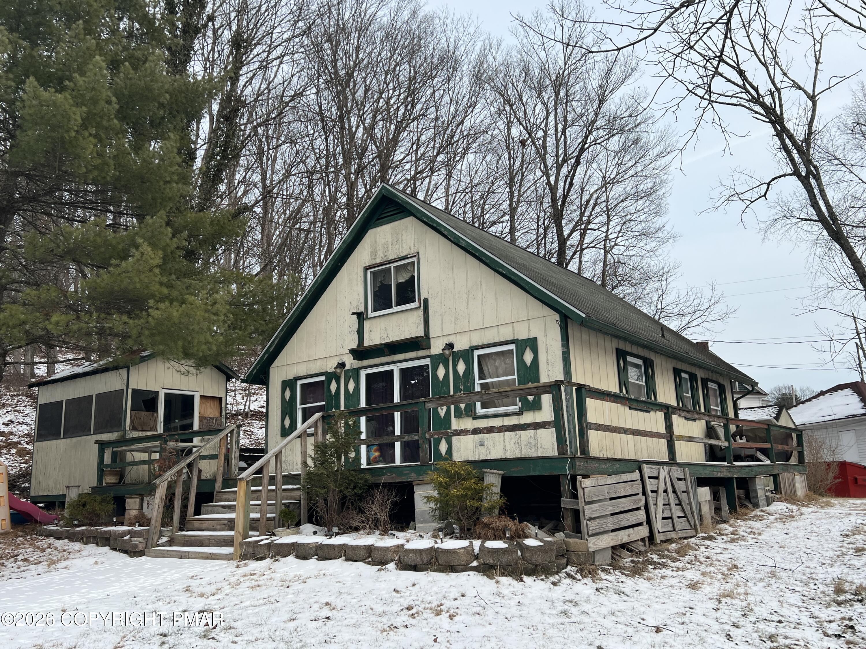 a front view of a house with a yard covered in snow