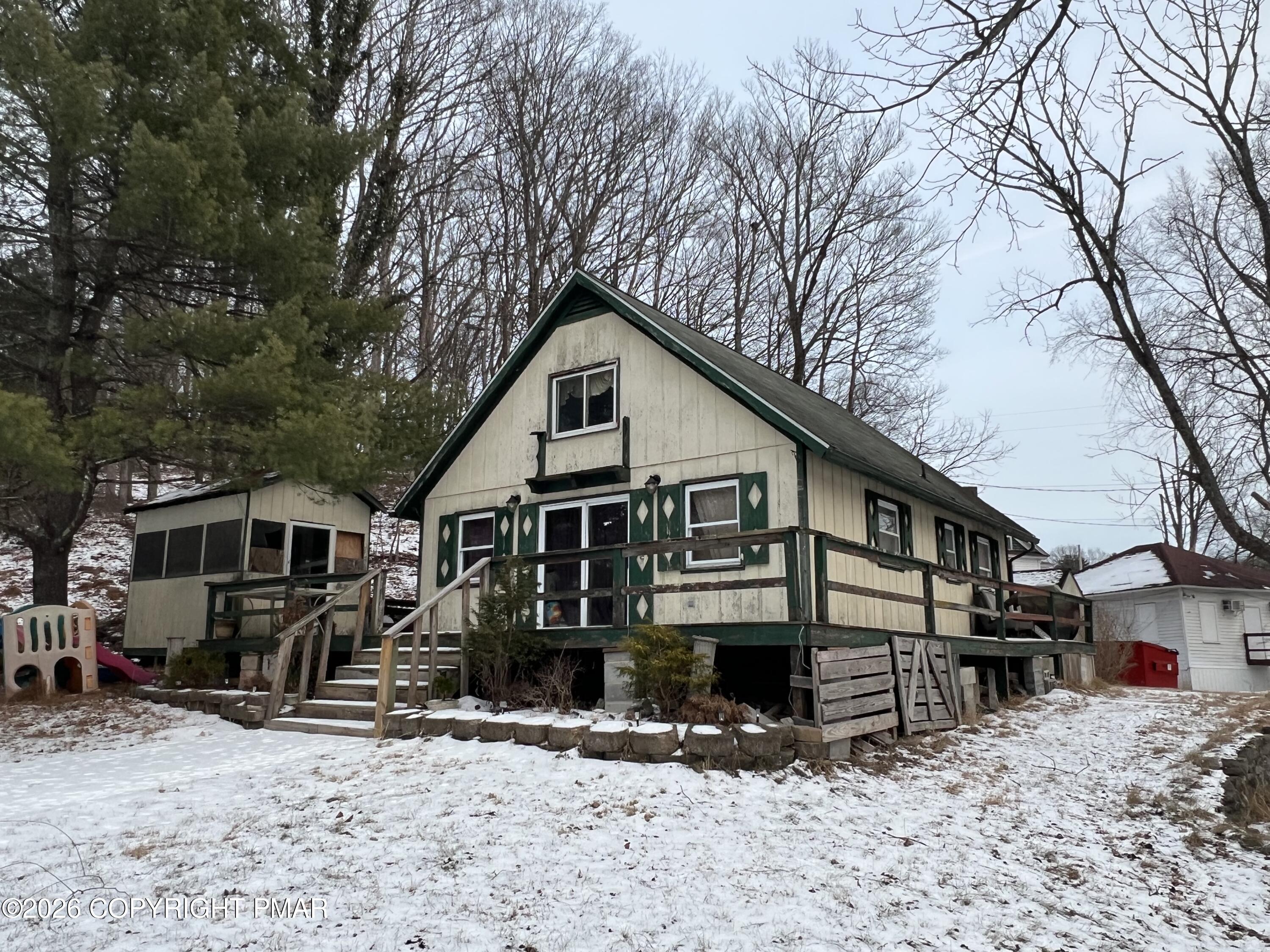 5062 Pine Ridge Road North East Stroudsburg, PA 18302 - Photo 3 of 17 a front view of a house with a yard covered in snow