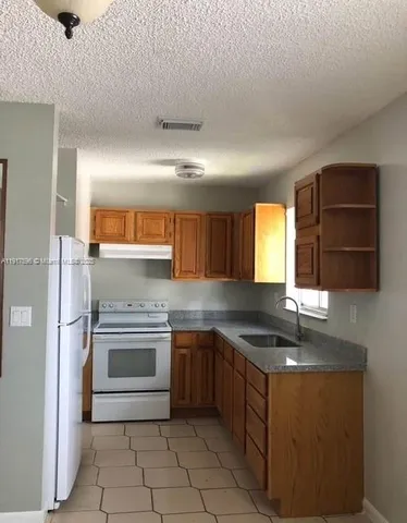 a kitchen with stainless steel appliances granite countertop a sink and a stove