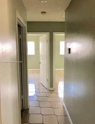 a view of a hallway to a livingroom with furniture