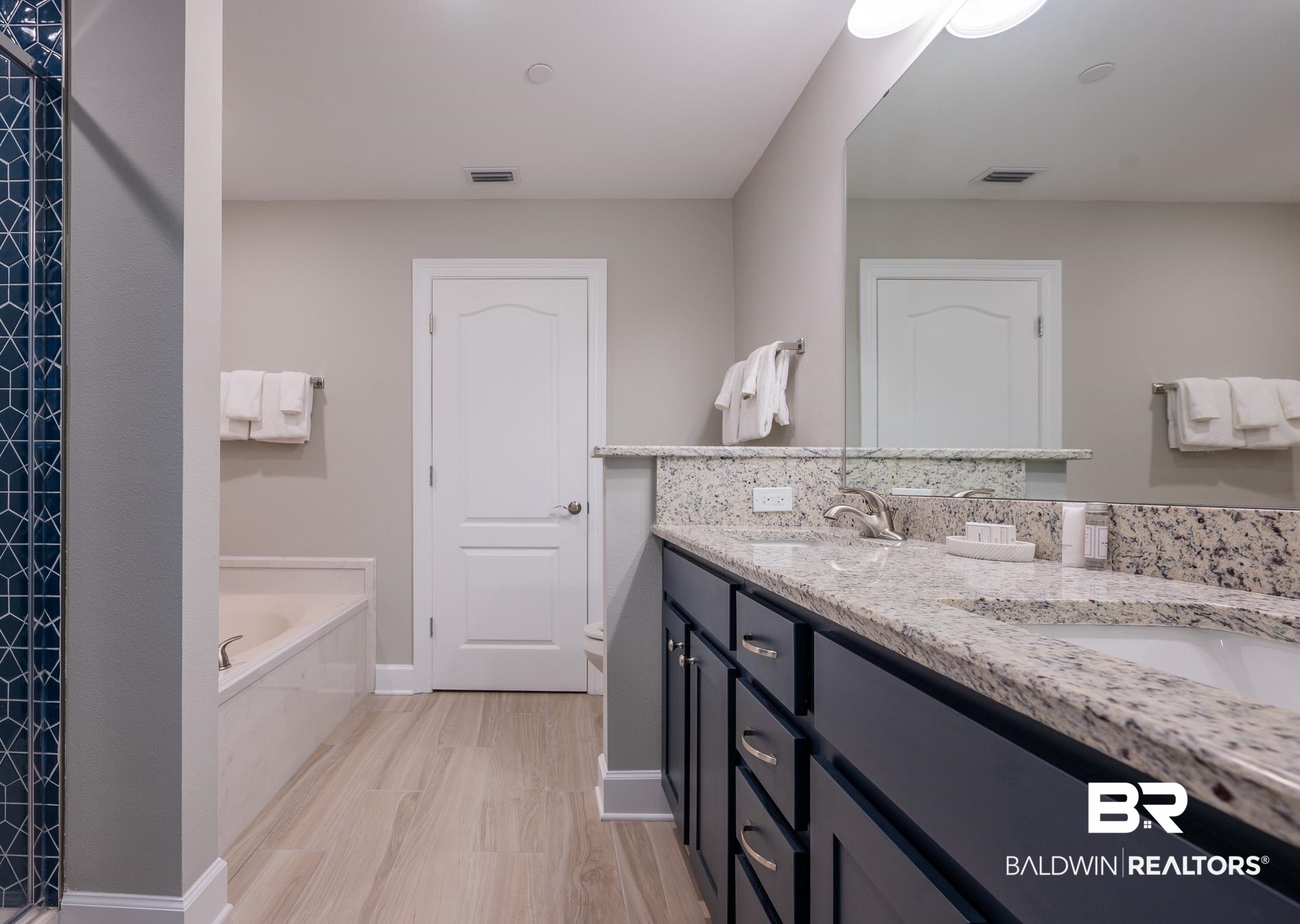 23008 Perdido Beach Boulevard, Unit 506 Orange Beach, AL 36561 - Photo 14 of 48 Bathroom with double vanity, visible vents, a sink, and a garden tub