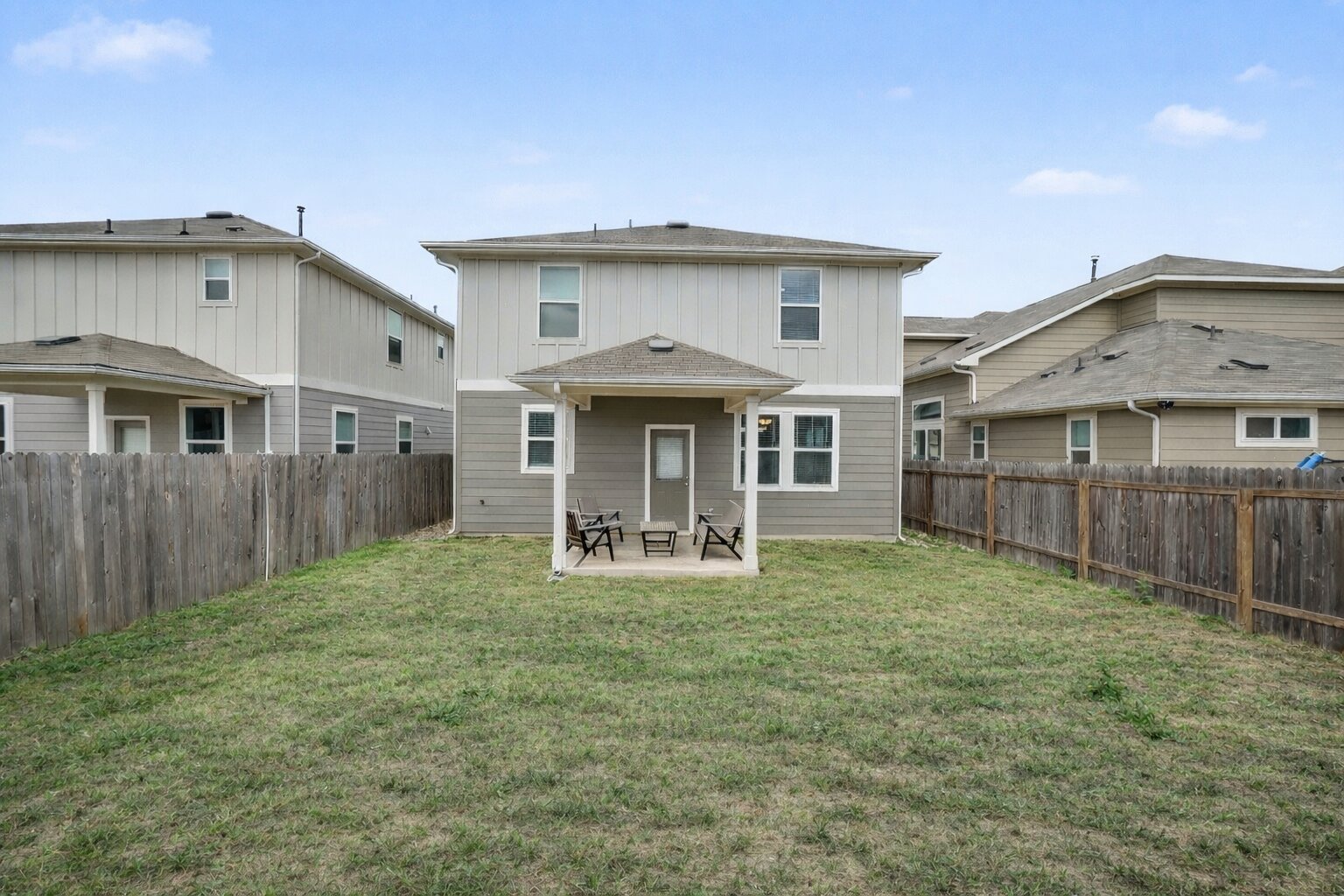 10807 Sentinel Drive Austin, TX 78747 - Photo 15 of 16 Back of property with a patio, a fenced backyard, and board and batten siding