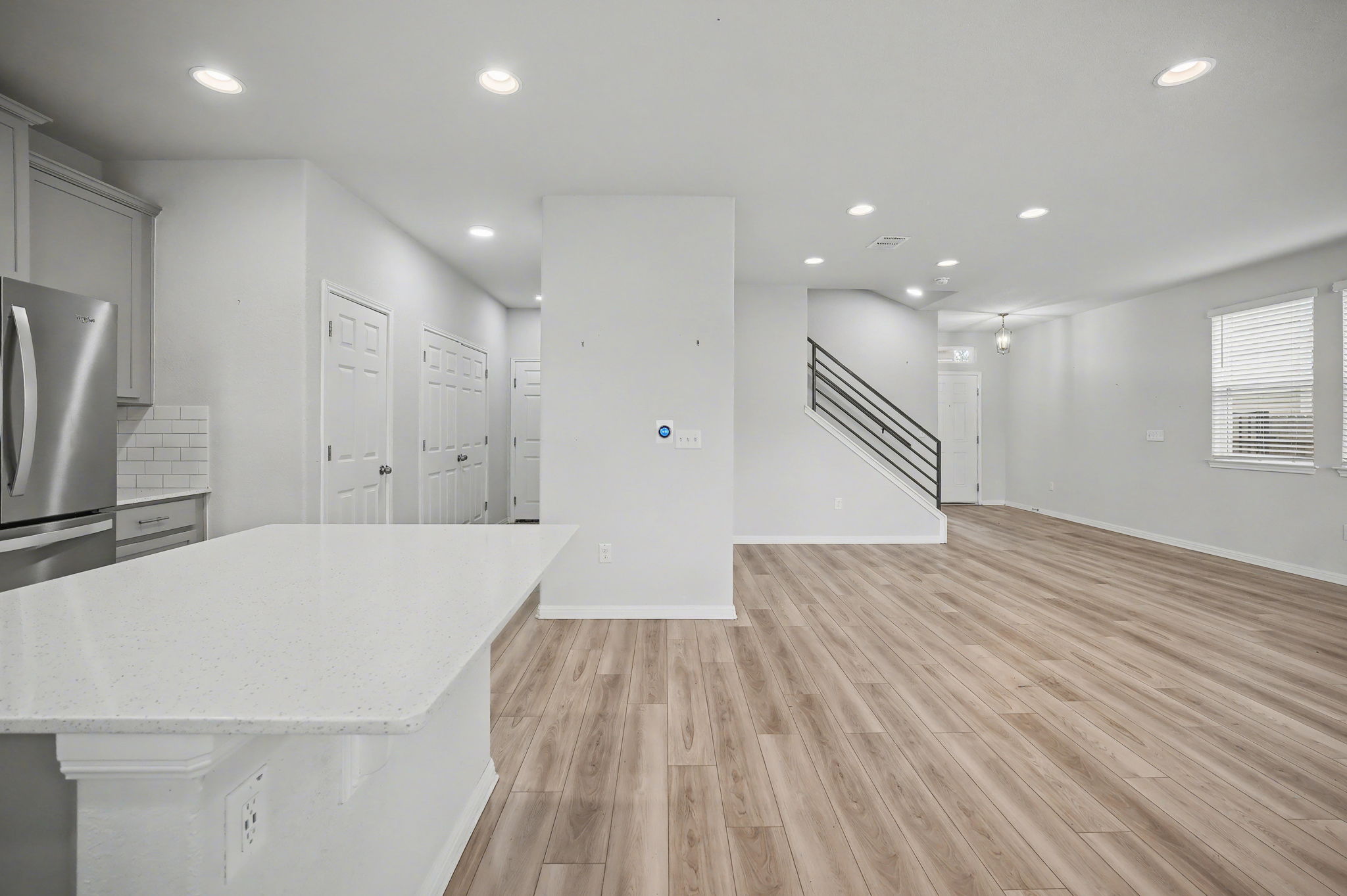 10807 Sentinel Drive Austin, TX 78747 - Photo 4 of 16 Kitchen with light wood-style flooring, freestanding refrigerator, recessed lighting, light stone countertops, and a kitchen island