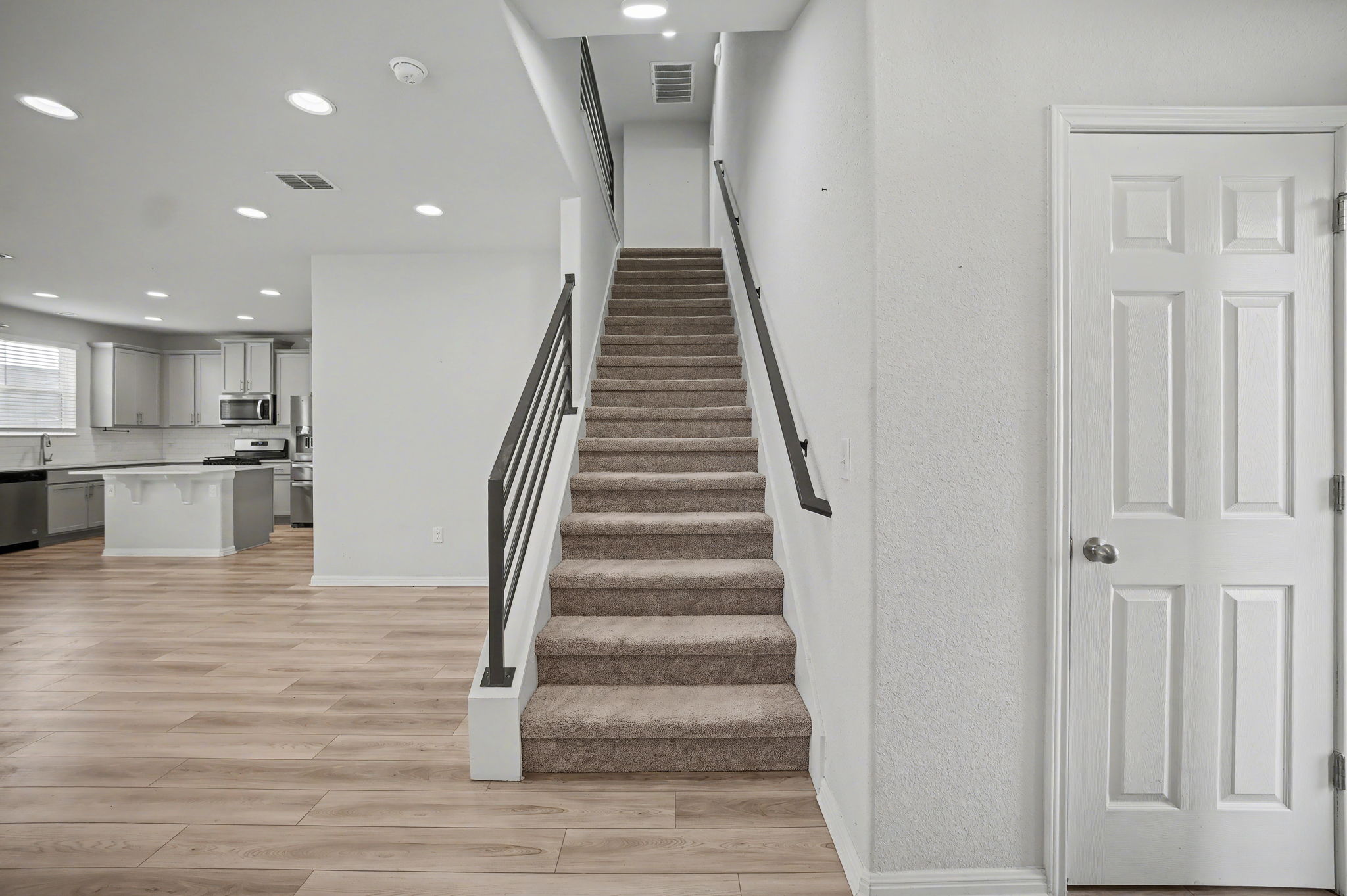 10807 Sentinel Drive Austin, TX 78747 - Photo 6 of 16 Stairway with wood finished floors and recessed lighting