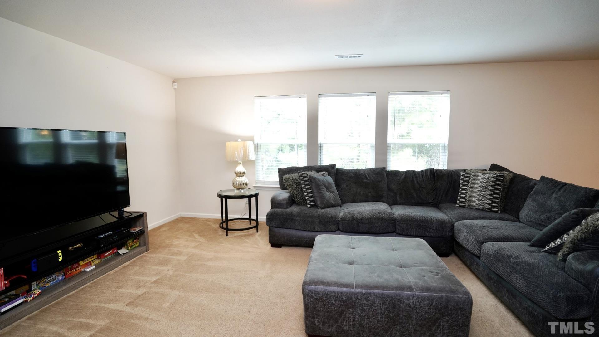 6813 Planting Court Raleigh, NC 27610 - Photo 2 of 9 a living room with furniture and a flat screen tv
