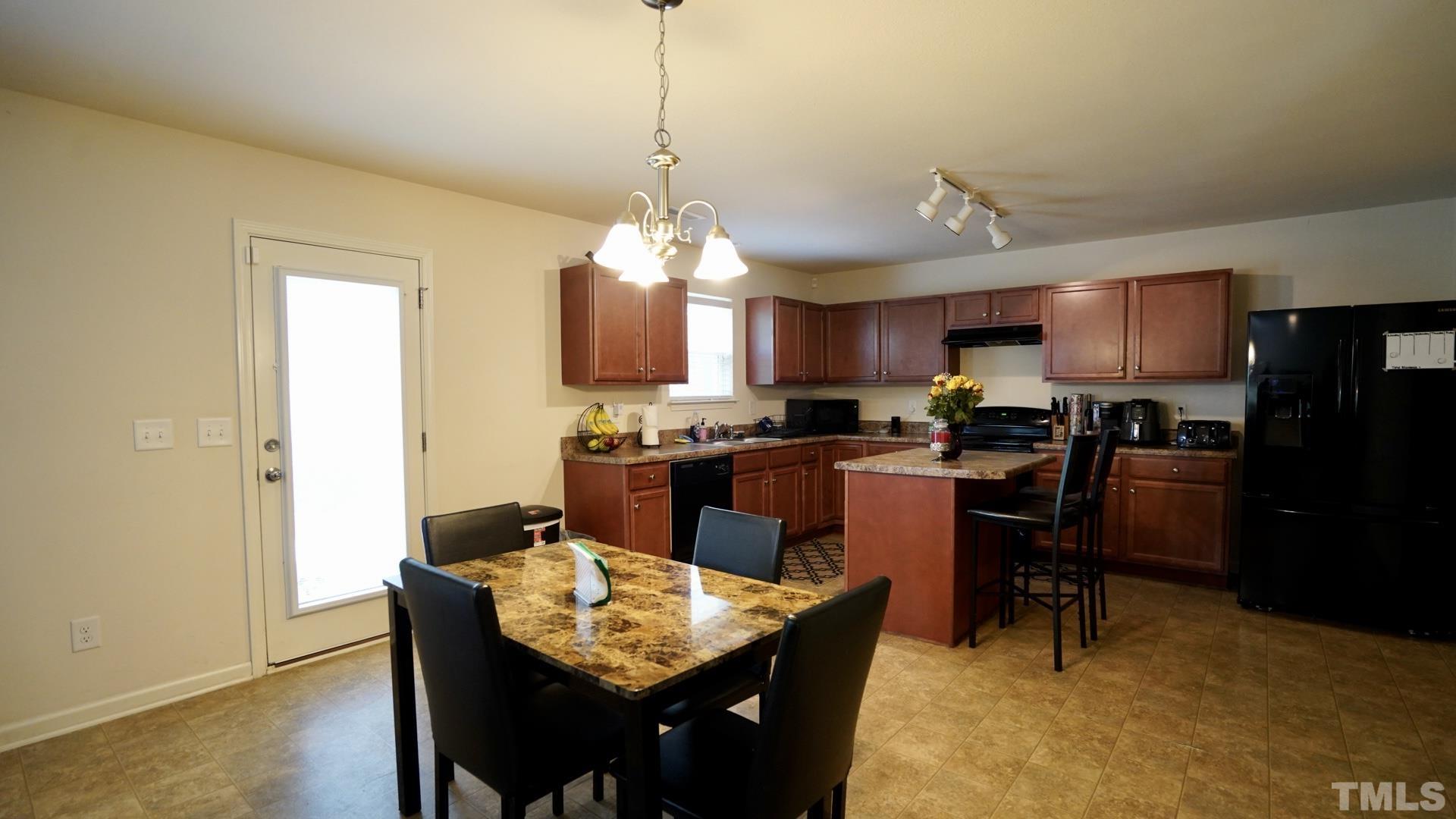 6813 Planting Court Raleigh, NC 27610 - Photo 3 of 9 a kitchen with a dining table chairs and refrigerator