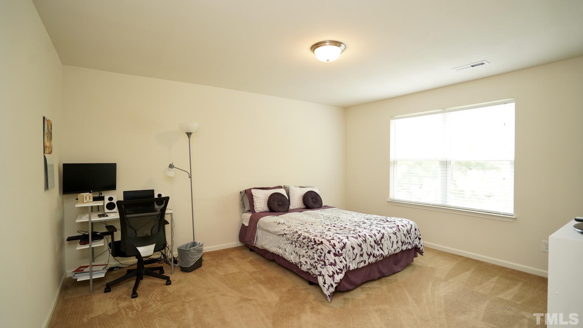 6813 Planting Court Raleigh, NC 27610 - Photo 6 of 9 a bedroom with a bed a desk and a window