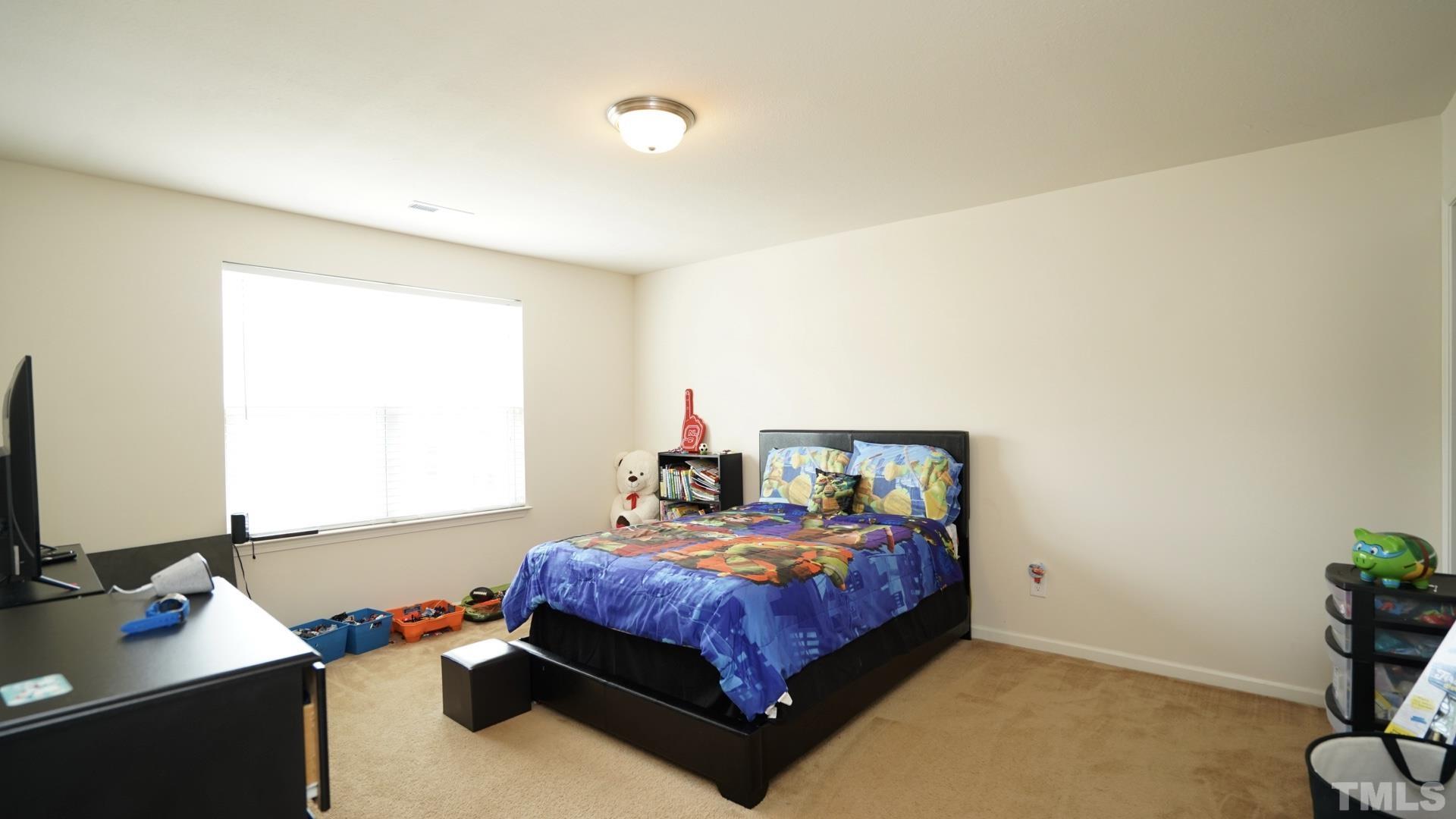 6813 Planting Court Raleigh, NC 27610 - Photo 7 of 9 a bed room with a bed window and a table