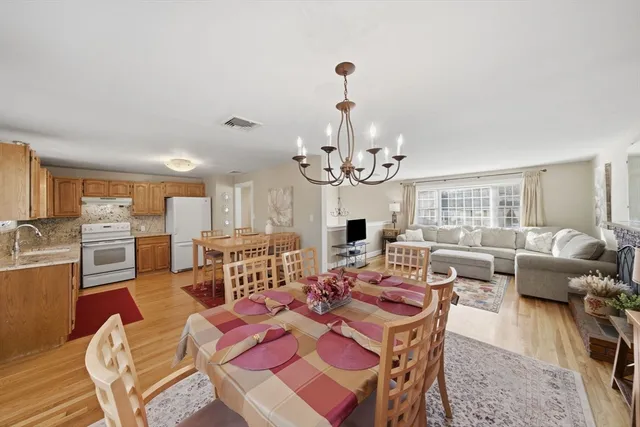 a view of a dining room with furniture a rug and wooden floor