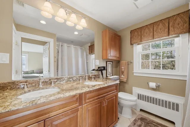 a bathroom with a granite countertop sink and a window