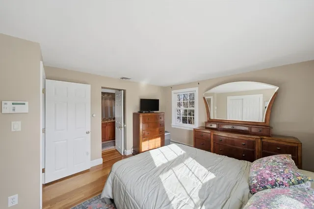 a bedroom with a bed and dresser with mirror