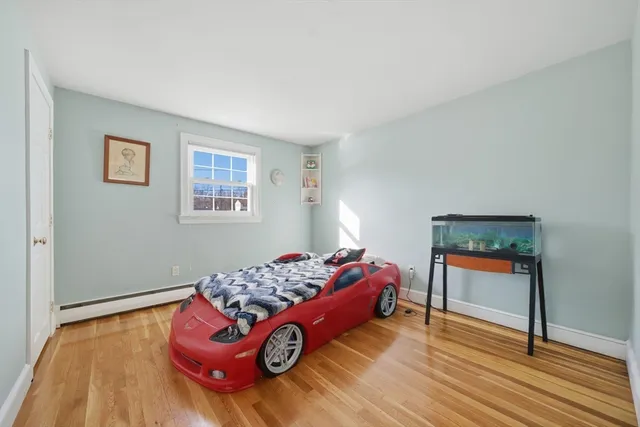 a bedroom with a bed and a dresser next to a window