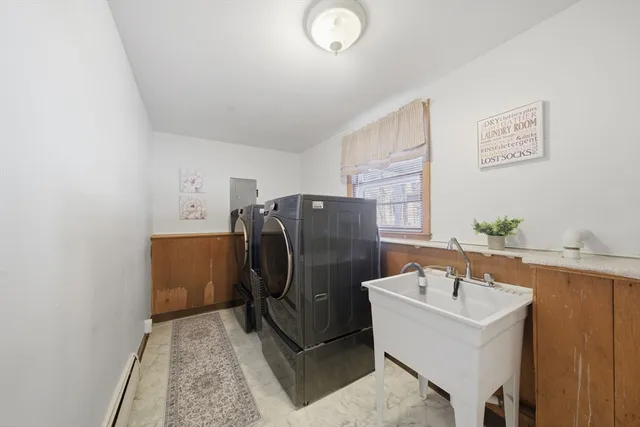 a bathroom with a sink a window and stainless steel appliances
