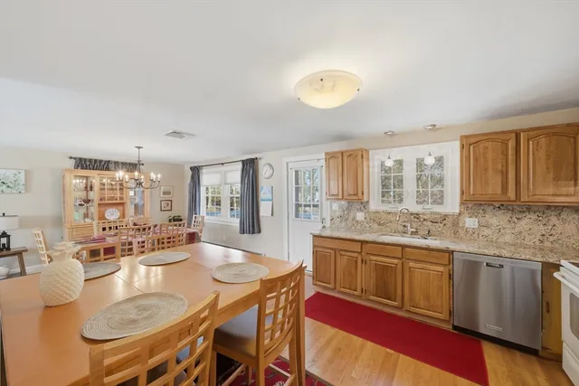 a large kitchen with granite countertop a stove a sink a dining table and chairs